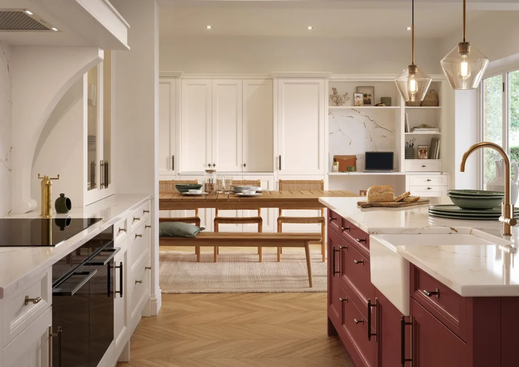 Bespoke antique red kitchen island with belfast sink, marble worktop and brass tap beside open-plan dining and built-in study nook.