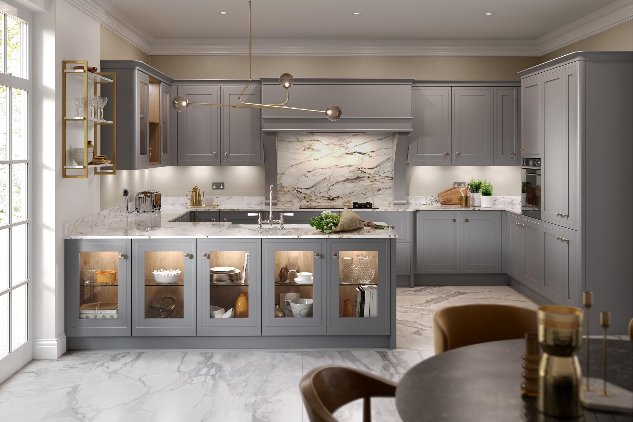 Bespoke Kitchens by Georgie Hall dust grey kitchen with glazed island, gold veined marble splashback, canopy hood and brass chandelier.